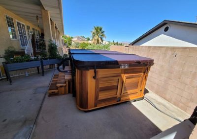 covered all weather pool arctic spas in red cedar cabinet in the backyard